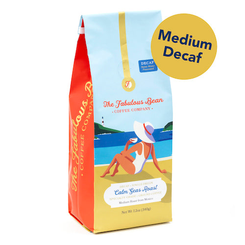 Fabulous Bean Coffee's Calm Seas Medium Ground Roast in a 12 ounce bag featuring a sophisticated woman enjoying coffee on a beautiful beach