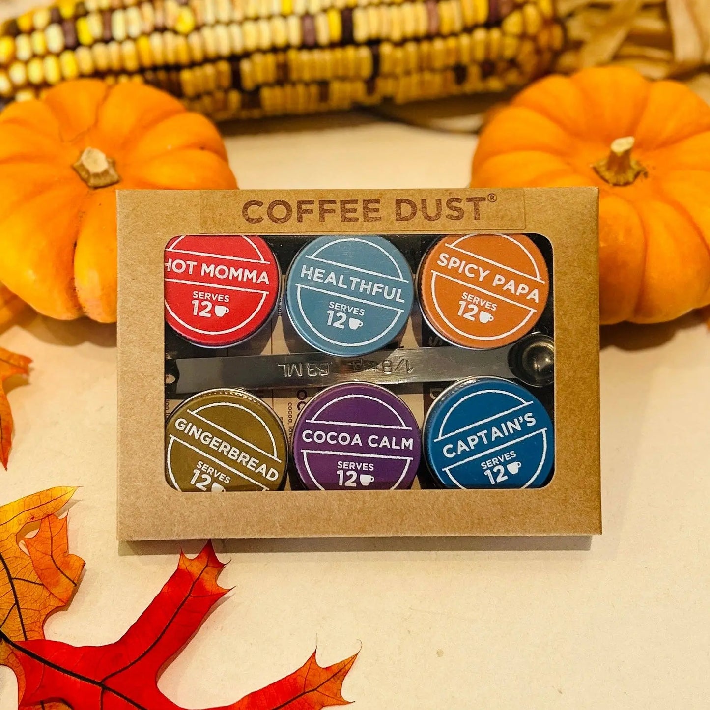 Box of Vashon Island Coffee Dust with colorful labels on a autumn-themed background.