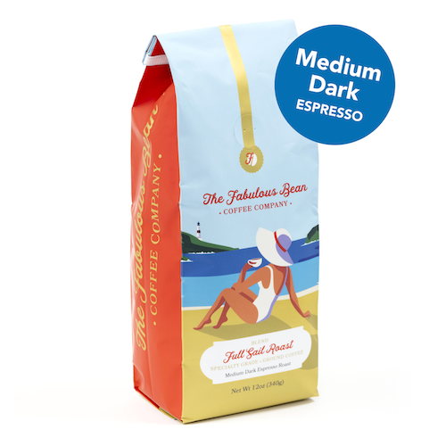 Fabulous Bean Coffee's Full Sail Medium-Dark Espresso Ground Roast in a 12 ounce bag featuring a sophisticated woman enjoying coffee on a beautiful beach