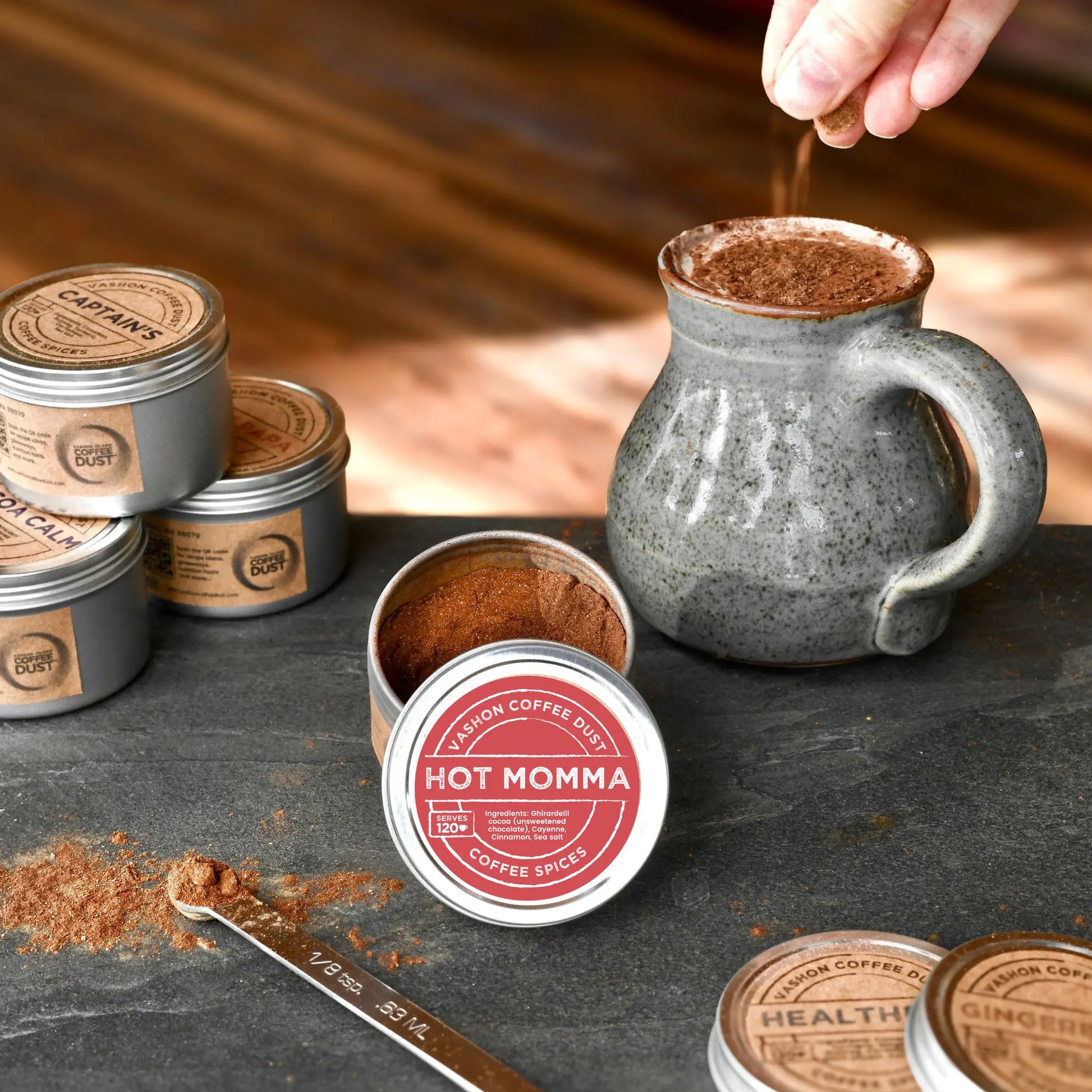 Hot chocolate being prepared with 'Hot Momma' coffee dust from Vashon Island Coffee Dust on a wooden surface.