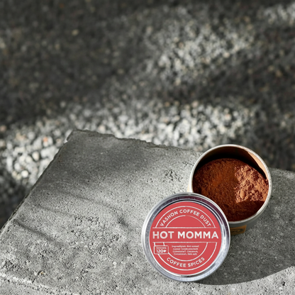 Full-size tin of Vashon Island Hot Momma coffee dust on a textured surface.