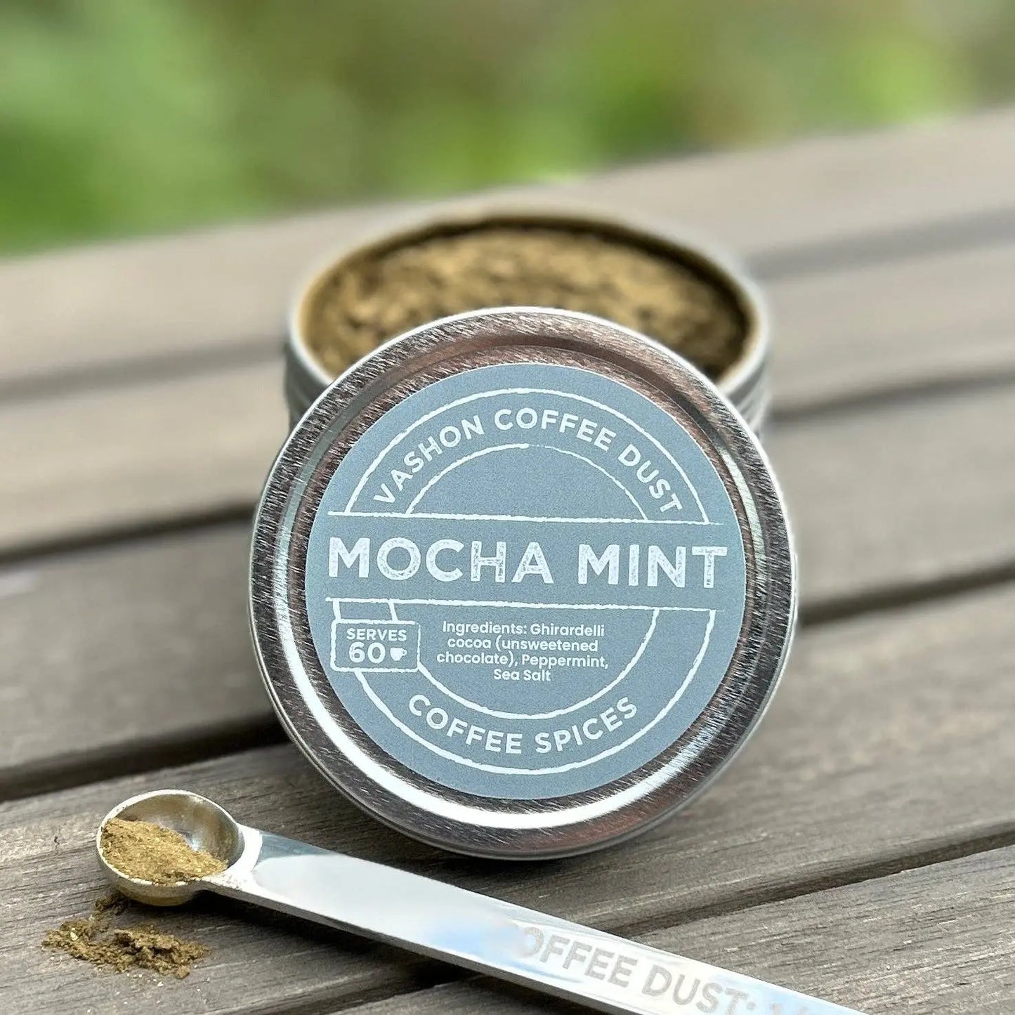 Mocha Mint coffee dust container with a measuring spoon on a wooden surface