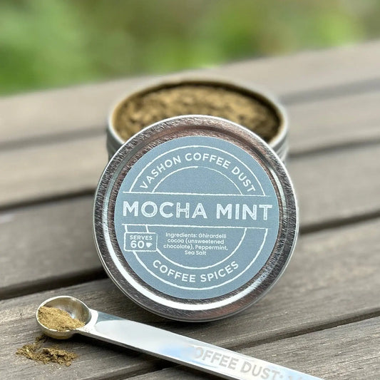 Mocha Mint coffee dust container with a measuring spoon on a wooden surface