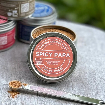 Vashon Island Spicy Papa coffee dust container with a spoonful of ground spices on a wooden surface.